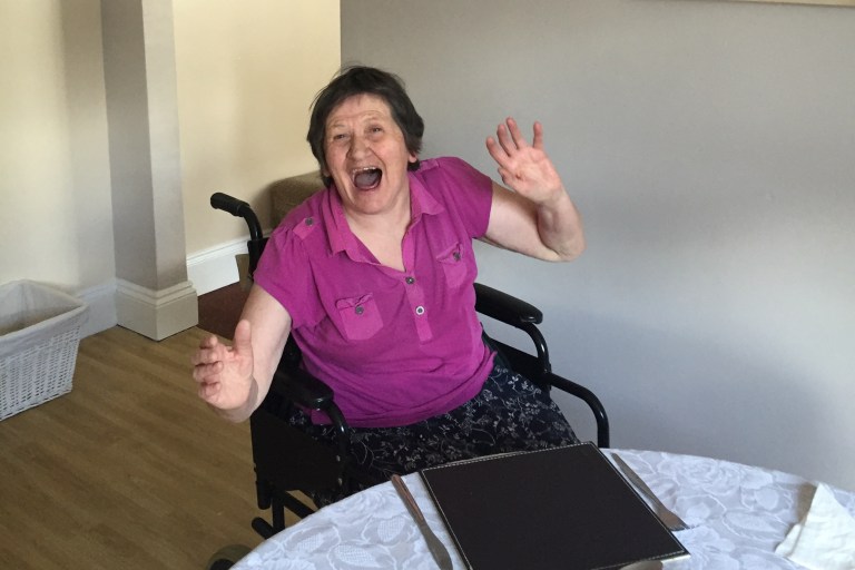 a woman on a wheelchair cheering and laughing