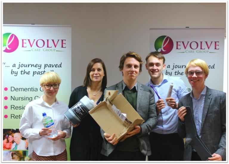 a group of young people dressed smart holding up a box