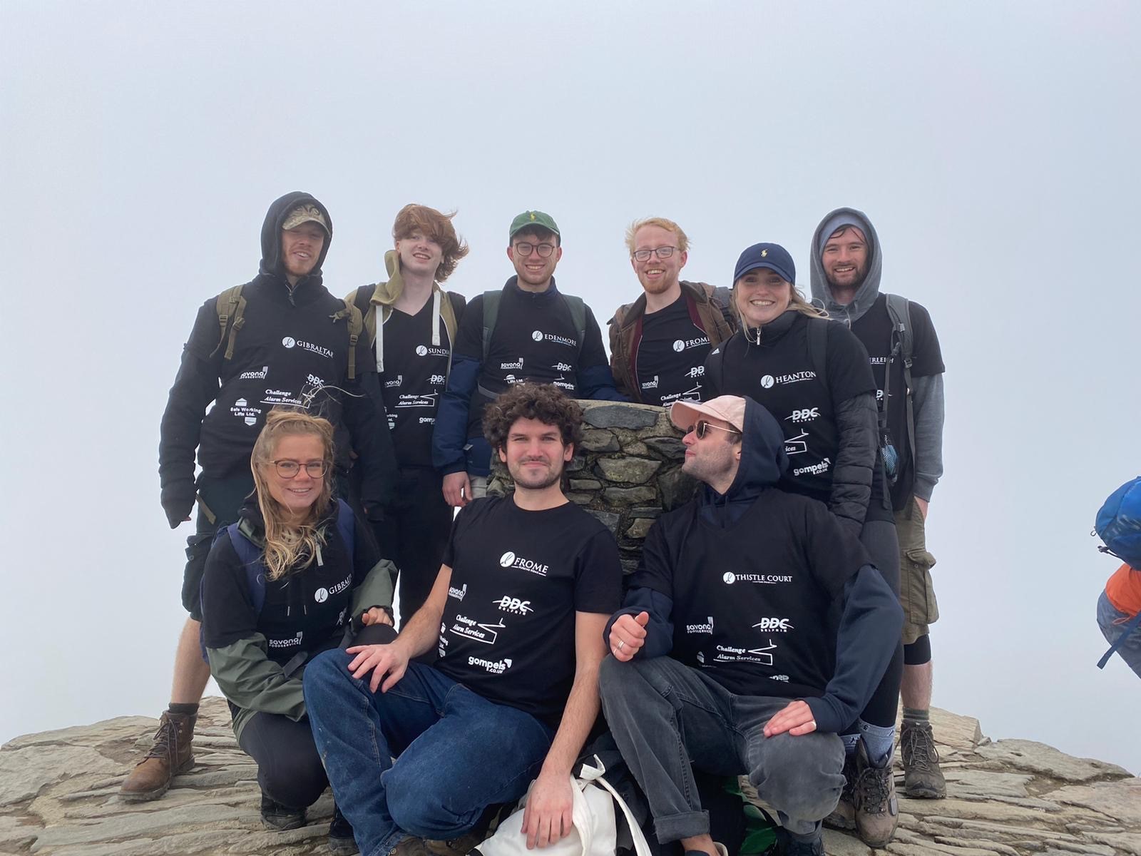 a group of people at the to of a mountain on a cloudy day